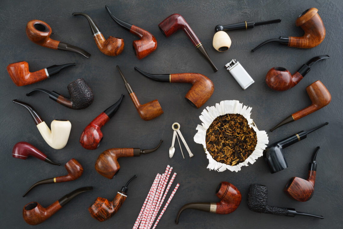 Colección de pipas de tabaco de distintos estilos y colores junto a tabaco suelto, ideal para quienes buscan su primera pipa